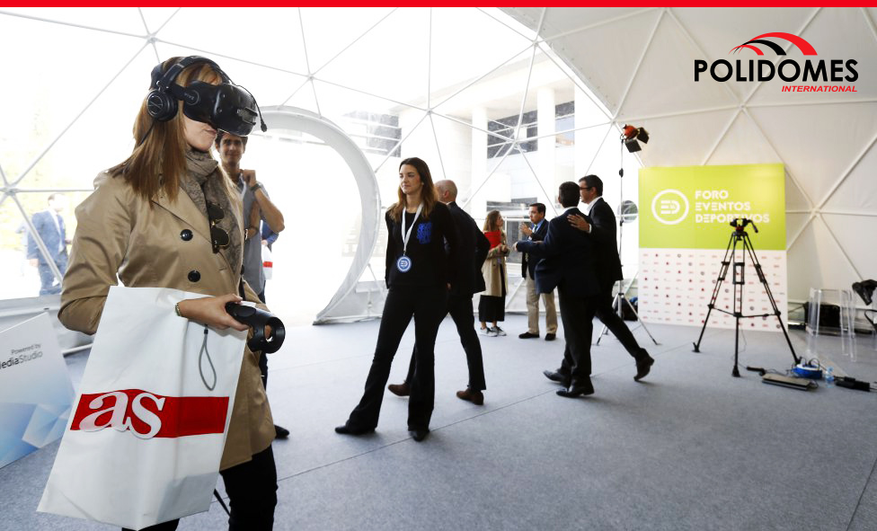 people testing virtual reality with 3D glasses in geodesic event tent